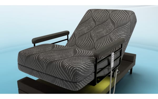 Freedom Twin XL Lift Bed with black patterned memory foam mattress, adjustable metal frame, padded armrests, and remote control for reclining and standing functions.