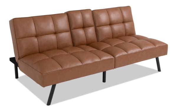 Dallas Cognac Futon in transitional style with brown faux leather upholstery, tufted cushions, and angled black legs, designed for comfort and durability.