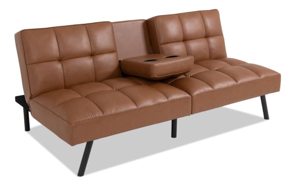 Dallas Cognac Futon in transitional style with brown faux leather upholstery, tufted cushions, drop-down table with cup holders, and angled black legs.