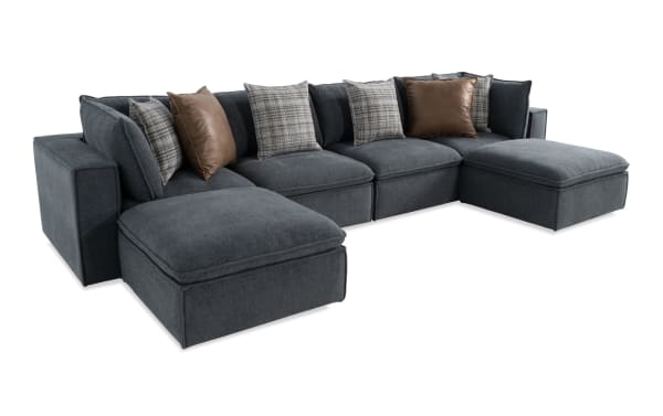 Transitional Infinity Thunder Blue 150'' 6-piece modular sectional with blue polyester fabric, featuring 2 armless chairs, 2 corners, 2 ottomans, and mixed plaid and leather accent pillows.