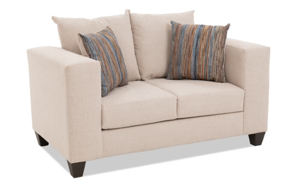 Haley 61'' beige loveseat with polyester fabric upholstery, transitional style, includes two striped accent pillows, and tapered dark wood legs.