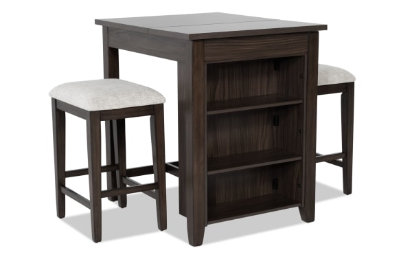 Homeworks 3 Piece Dark Brown & Gray Upholstered Counter Height Kitchen Island Set with adjustable shelves, lift-top storage, and cushioned stools in transitional style. Made of melamine, MDF, plywood, rubberwood, and polyester fabric upholstery. Durable, moisture and stain-resistant finish.