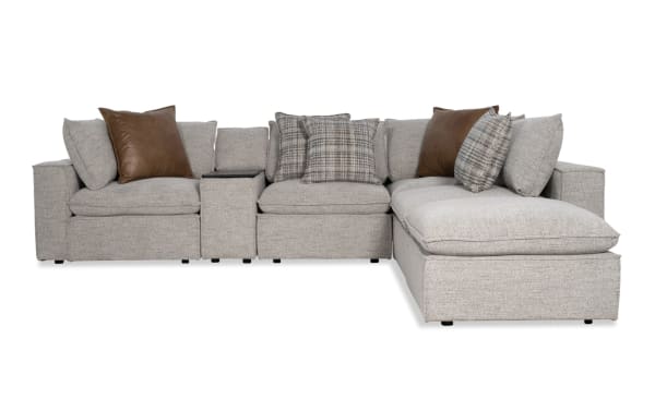 Infinity Gray 117'' 6 Piece Modular Sectional in transitional style with gray polyester fabric, featuring 2 armless chairs, 2 corners, media console, and ottoman. Includes Bob-O-Pedic® stuffed seats, feather-blend pillows, Bluetooth speakers, removable back cushions, and a sturdy Siberian pine frame.