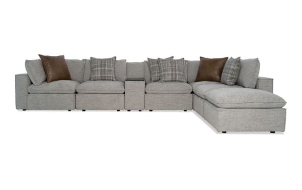 Infinity Gray 117" 7-piece modular sectional in gray polyester fabric with 3 armless chairs, 2 corners, media console, and ottoman. Transitional style with Bob-O-Pedic® cushions, feather blend pillows, Bluetooth speakers, removable back cushions, sinuous seating, and Siberian pine frame.