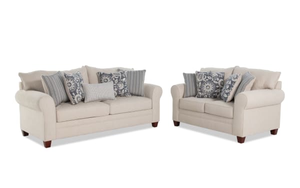 Portland Beige 85'' sofa and 65'' loveseat set in beige polyester fabric, transitional style with rolled arms and multiple patterned accent pillows.