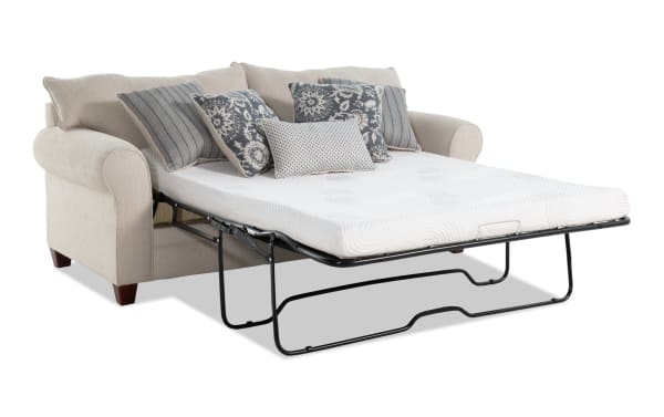 Beige Portland 85'' transitional sleeper sofa with rolled arms, polyester fabric upholstery, accent pillows, and queen gel memory foam mattress extended for sleeping.