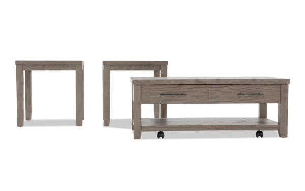 Set of three gray wood tables including a rectangular coffee table with two drawers and caster wheels, and two matching square side tables with straight legs, suitable for living room furniture.