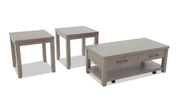 Set of three gray wooden tables including two square side tables and one rectangular coffee table with drawers and lower shelf on wheels.