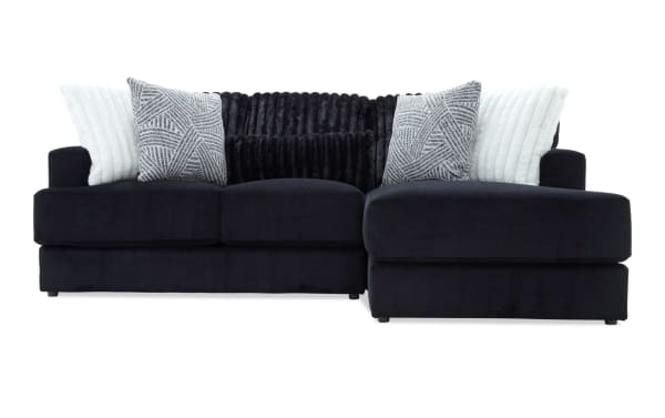 Sofia Black 98'' 2 Piece Right Arm Facing Chaise Sectional in black polyester fabric, transitional style with channel tufted back cushions and five faux fur pillows.