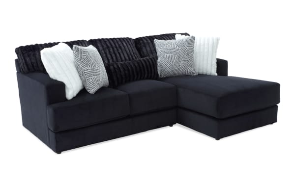 Sofia Black 98'' 2 Piece Right Arm Facing Chaise Sectional in black polyester fabric with channel tufted back cushions and five faux fur pillows, transitional style.