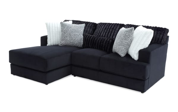 Sofia Black 98'' 2 Piece Left Arm Facing Chaise Sectional in black polyester fabric with channel tufted back cushions and five faux fur pillows, transitional style.
