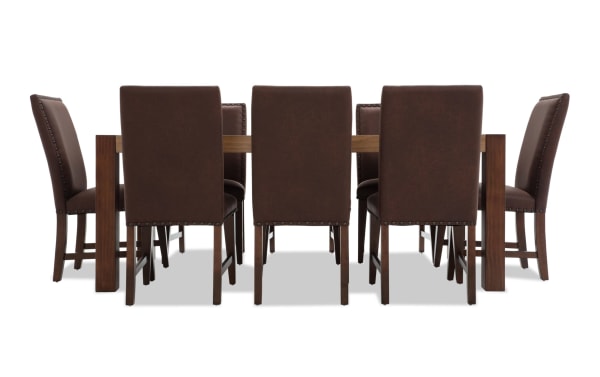 Canyon 9 Piece Brown Faux Leather Upholstered Dining Set with rustic multi-tone MDF wood table and brown faux leather chairs featuring memory foam cushioning.