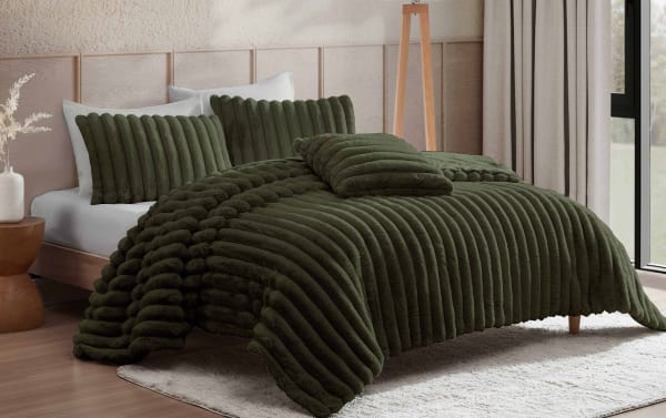 Dark green plush comforter set on wooden bed with matching pillows, featuring ribbed and tufted textures, in modern bedroom setting.