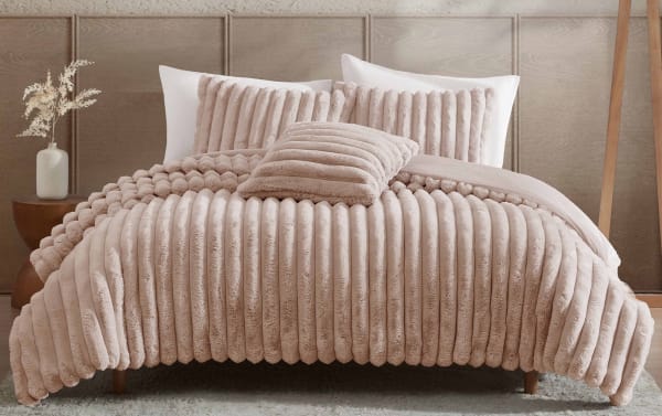 Luxurious beige plush velvet comforter set with ribbed texture, matching pillows, and soft decorative cushion on king-size bed.