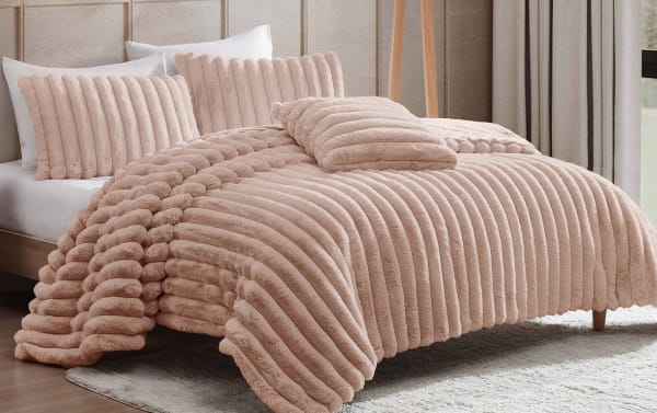 Plush pink ribbed microfiber comforter set on bed, featuring matching decorative pillows and soft textured fabric for cozy bedroom decor.