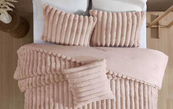 Soft beige ribbed plush bedding set with matching pillows on a modern bed, featuring textured velvet fabric for cozy bedroom decor.