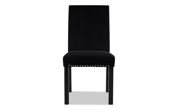 Black upholstered dining chair with high backrest, velvet fabric, wooden legs, and silver nailhead trim along seat edge.
