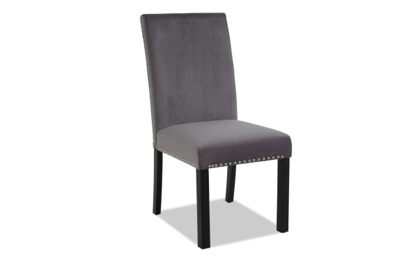 Gray upholstered dining chair with high back, silver nailhead trim, and black wooden legs, suitable for modern home decor.