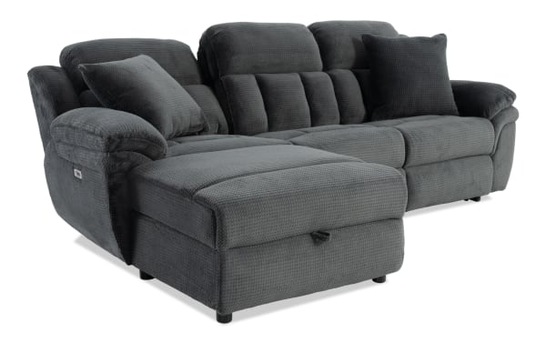 Dark gray fabric sectional sofa with plush cushions, padded armrests, and two matching throw pillows, designed for living room comfort.