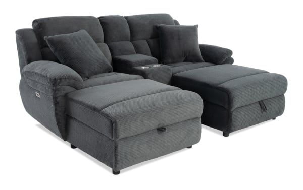 Dark gray fabric reclining sectional sofa with plush cushions, two matching pillows, and built-in cup holders, designed for comfort and relaxation.