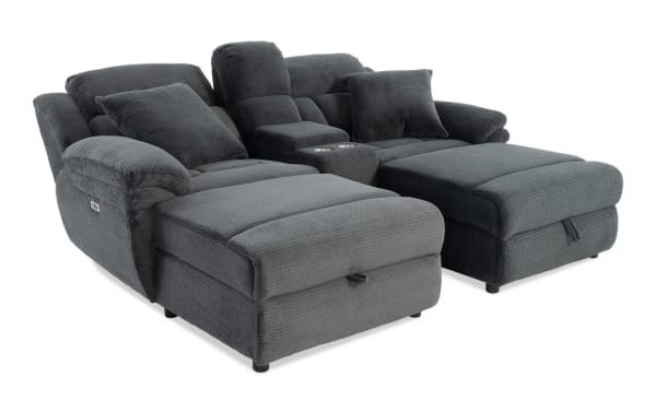 Dark gray fabric reclining loveseat with plush cushions, two cup holders, and padded armrests, designed for comfort and relaxation.