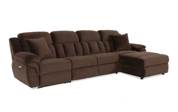 Brown plush fabric sectional sofa with reclining seats and chaise lounge, featuring padded armrests and matching cushions for living room comfort.