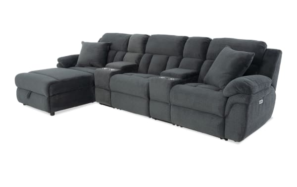 Dark gray fabric sectional sofa with plush cushioning, reclining seats, cup holders, and matching throw pillows, designed for living room comfort.