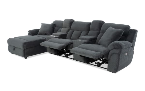 Dark gray fabric sectional sofa with reclining seats, chaise lounge, cup holders, and plush cushions, designed for living room comfort.