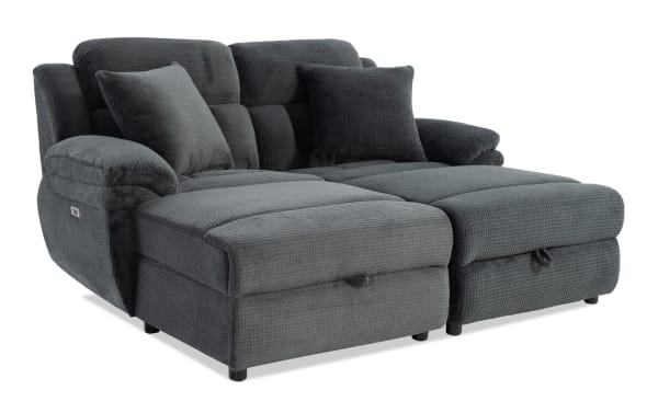 Dark gray fabric sectional sofa with plush cushions, padded armrests, and two matching throw pillows, designed for comfort and modern living rooms.