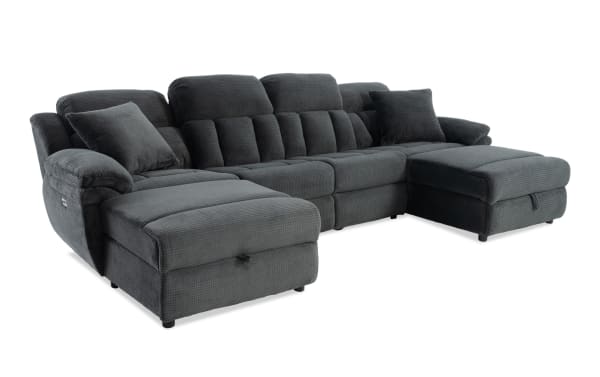 Dark gray fabric sectional sofa with plush cushions, padded armrests, and two matching throw pillows, designed for comfortable living room seating.