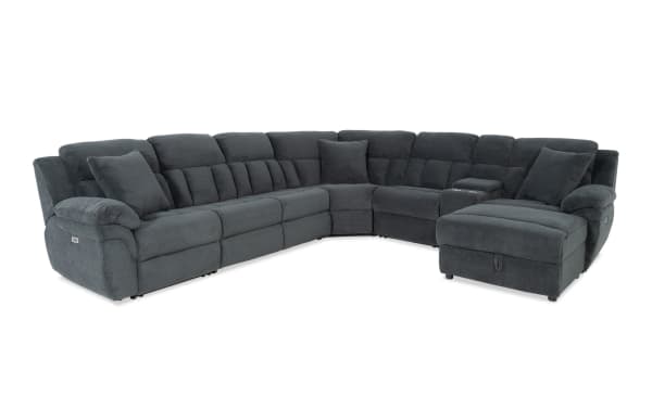 Dark gray sectional sofa with plush cushions and reclining seats, featuring a soft textured fabric and corner design for spacious living room seating.