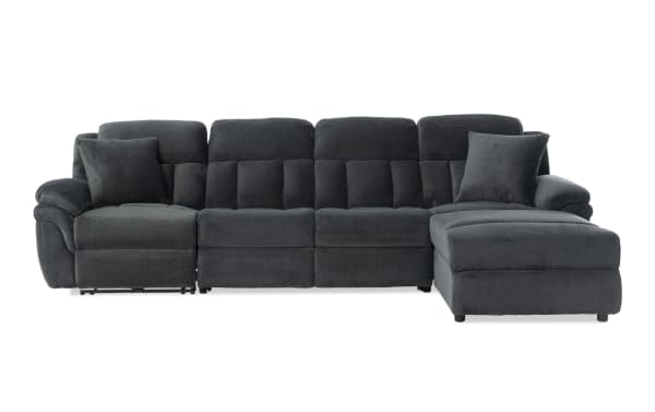 Dark gray fabric sectional sofa with plush cushions, padded armrests, and two matching throw pillows, featuring a chaise lounge on the right side.