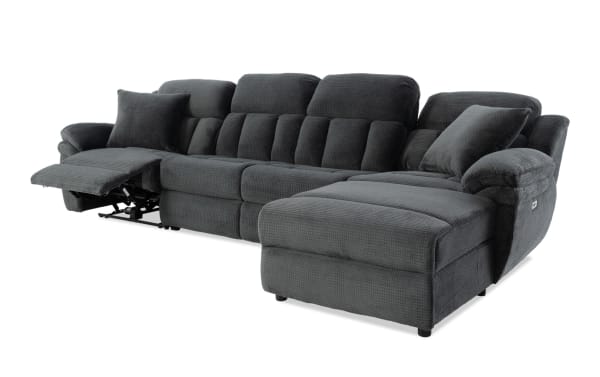 Dark gray fabric sectional sofa with plush cushions, reclining seat on the left side, and chaise lounge on the right, ideal for living room comfort.