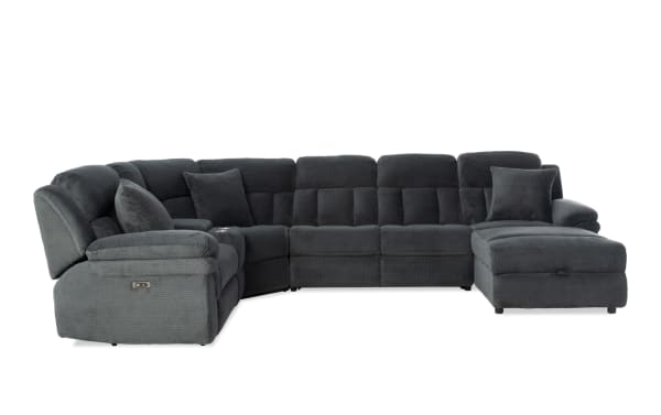 Dark gray fabric sectional sofa with plush cushions, reclining seats, and chaise lounge, designed for modern living room comfort.