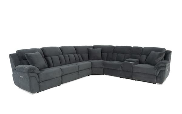 Dark gray fabric sectional sofa with plush cushioned seats, reclining features, cup holders, and multiple matching throw pillows, ideal for living room comfort.