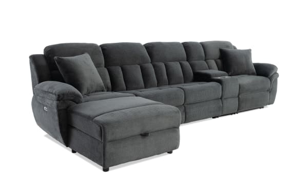 Dark gray fabric sectional sofa with plush cushioning, padded armrests, two matching throw pillows, and a built-in console with cup holders.