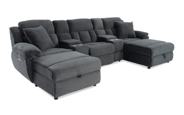 Dark gray fabric sectional sofa with plush cushions, reclining seats, cup holders, and chaise lounges for living room comfort and style.