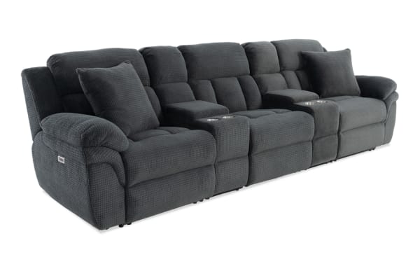 Dark gray textured fabric reclining sectional sofa with plush cushions, cup holders, and padded armrests, designed for comfort and home theater use.