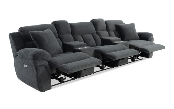 Dark gray fabric reclining sectional sofa with textured upholstery, three seats with footrests extended, built-in cup holders, and plush cushions.