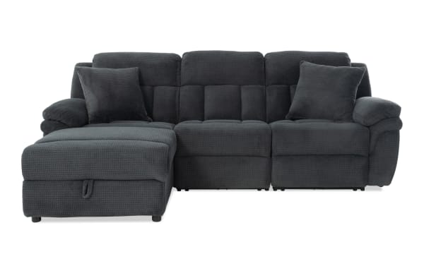 Dark gray fabric sectional sofa with plush cushions, padded armrests, and two matching throw pillows, featuring a chaise lounge on the left side.