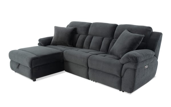 Dark gray fabric sectional sofa with plush cushions, chaise lounge on left, padded armrests, and two matching throw pillows, ideal for living room seating.