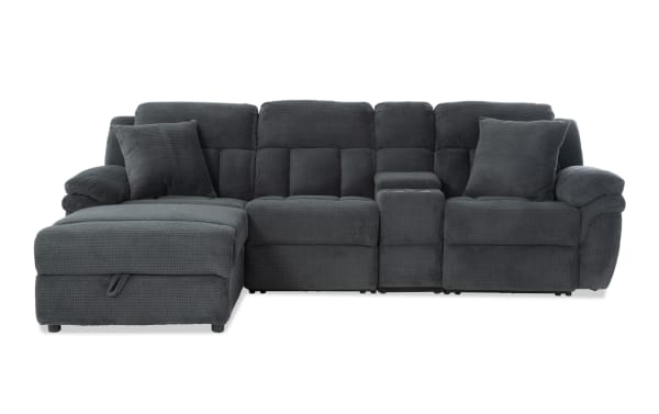 Dark gray fabric sectional sofa with a chaise lounge on the left, featuring plush cushions, two matching throw pillows, and a center console with storage.