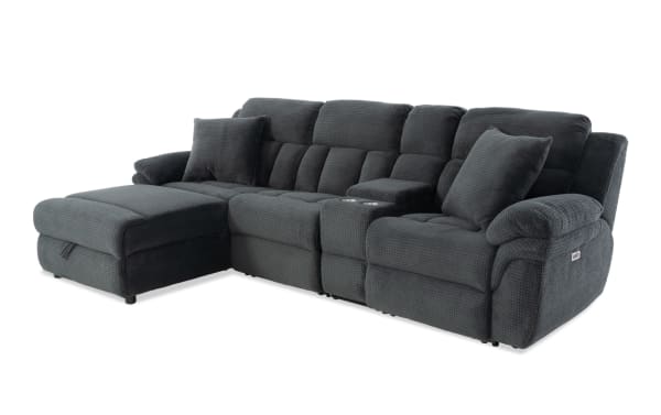 Dark gray fabric sectional sofa with chaise lounge, plush cushions, built-in cup holders, and reclining seats for living room comfort.