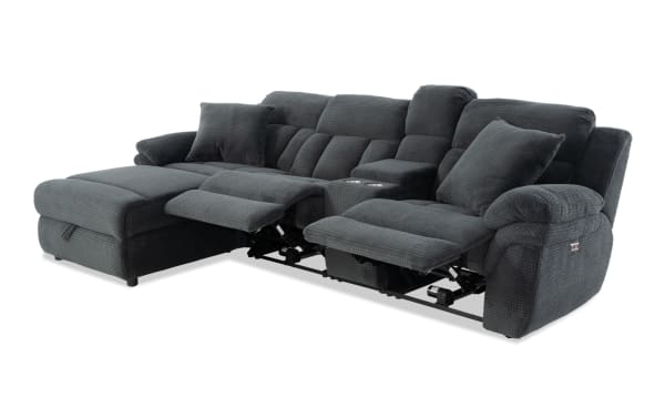 Dark gray fabric sectional sofa with reclining seats, cup holders, and plush cushions, designed for living room comfort and relaxation.