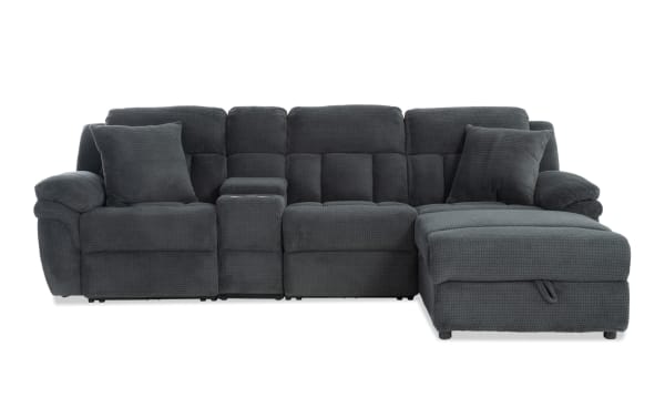 Dark gray fabric sectional sofa with plush cushions, padded armrests, and a chaise lounge on the right side, designed for modern living rooms.