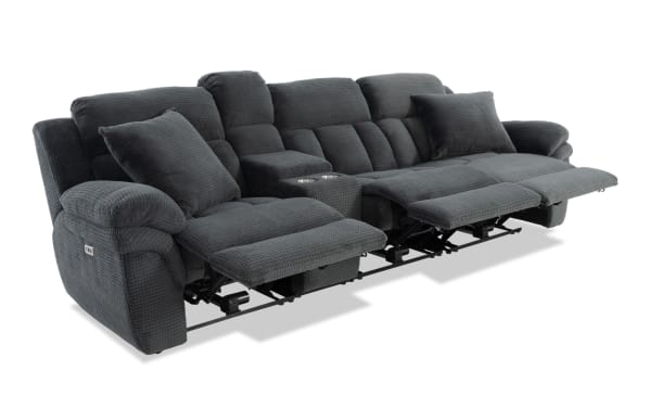Dark gray fabric reclining sectional sofa with plush cushions, two reclining seats, cup holders, and padded armrests for living room comfort.