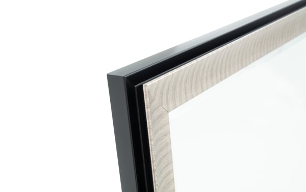 Close-up of a black and light wood grain picture frame corner with a glass front, showcasing modern and natural design elements.