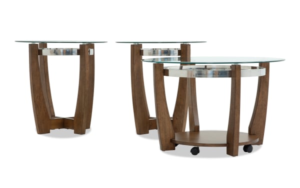 Set of three round wooden side tables with glass tops, featuring curved legs and metal accents, suitable for living room decor.