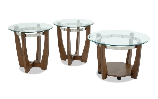 Set of three modern round glass top tables with wooden curved legs and metal accents, including a large coffee table with caster wheels and two smaller side tables.