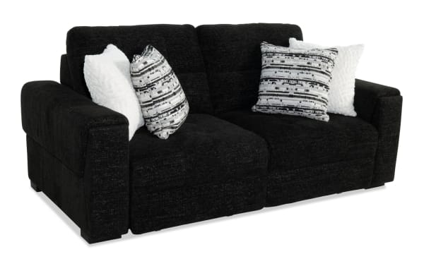 Black fabric loveseat sofa with wide armrests, tufted cushions, and four decorative pillows in white and black-and-white geometric patterns, ideal for modern living rooms.